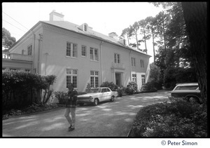 Exterior of house with cars parked in front and man walking along the driveway