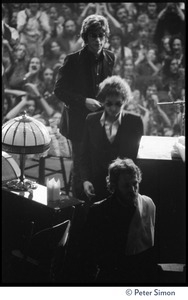 Bob Dylan walking on stage at the Boston Garden, with Levon Helm in front and Robbie Robertson behind