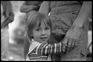 Child hugging the legs of her mother, Montague Farm Commune