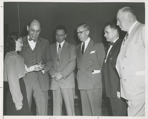 A group admires a woman's prosthetic arm