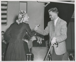 Unidentified woman handing a gift to a client using a cane at an ICD event