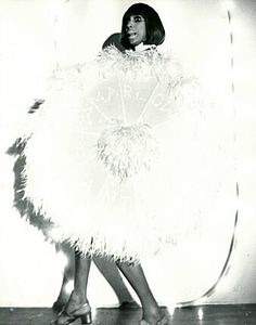 A Photograph of Marlow Monique Dickson Posing Behind a Feather Fan
