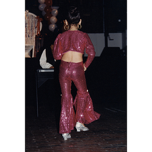 A girl in a sequined outfit faces away from the camera at a Festival Puertorriqueño event