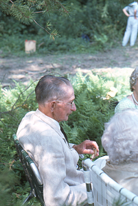 Arthur E. Rosenburg seated in lawn chair at the 2 August 1975 Moon Barn raising.
