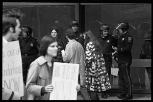 Police watch as antiwar demonstrators picket in front of the John F. Kennedy Federal Building