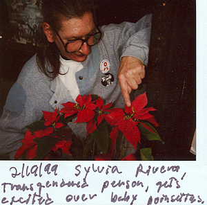 A Photograph of Sylvia Rivera Pointing at Baby Poinsettias