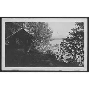 View of cabin, trees and lake at unidentified YMCA camp