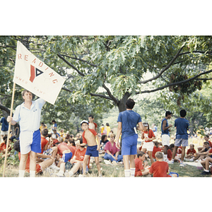 Crowd of children and a man holding a flag for Reading YMCA Summer Camp