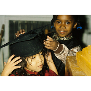 Young girl trying on a graduation cap