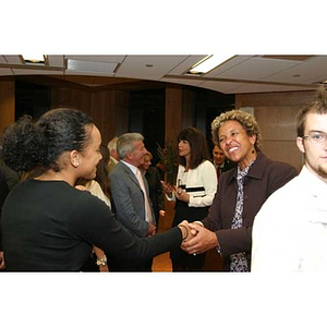 Melanie Arvajo shakes hands with a woman at the Torch Scholars dinner