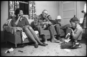 Mildred and Richard Loving (from left) seated on a couch with Richard's father, their son Donald seated on the floor in a cowboy outfit, playing with a puppy