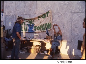 MUSE concert and rally: two men by an information table with sign that reads, 'we need pot, not plutonium'