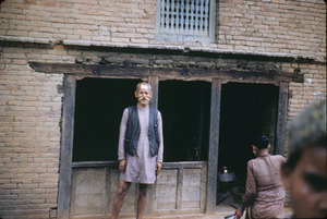 Old man outside his village home