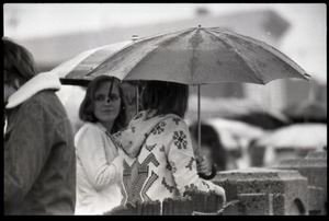 Two women with umbrella in the rain, awaiting the arrival of Gerald Ford to dedicate the Old Great Falls Historic District as a national historic landmark