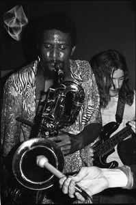 James Montgomery Band at Jack's: Montgomery holding a microphone to an unidentified baritone saxophone player's bell