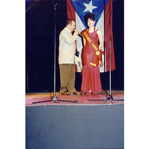 A man with a microphone speaks with Chamely Toro at the Festival Puertorriqueño
