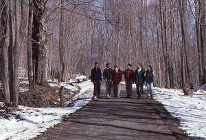 Norman E. Borlaug field trip to the Hopkins Memorial Forest. 1. Borlaug (in black hat) and HMF Permanent Plotters walk toward the Rosenburg Center on the Carriage Road Trail. Left to right: Permanent Plotters Tim Billo (Class of 1997), Henry W. Art, Peter McChesney (Class of 1975), Dawn Biehler (Class of 1997), Norman E. Borlaug (U MN, Class of 1937), Ben Montgomery (Class of 1998), and Emilie Grossmann (Class of 1996).