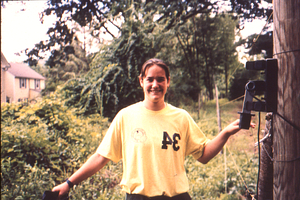 Christine Whitcraft (Class of 1999) at electric fence on SE corner of old Farm Manager's house on Bulkley Street.