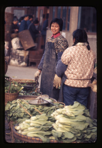 Young woman selling green vegetables