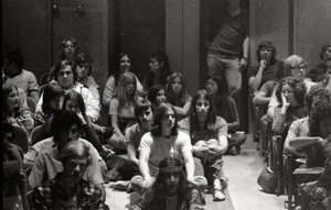 UMass Amherst students in a lecture hall, some seated on the floor