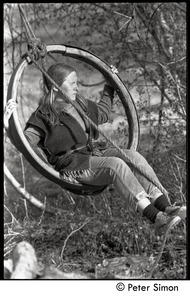 Evan Mahaffy swinging from an old wheel hung in a tree, Packer Corners commune