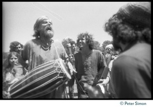 Bhagavan Das drumming on the lawn during Ram Dass's appearance at Sonoma State University, Peter Simon recording his singing