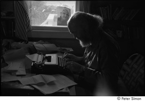 Ram Dass at typewriter: Ram Dass typing, with a portrait of Neem Karoli Baba in the background