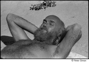Jungle Beach: Ram Dass laying in the sand with his eyes closed