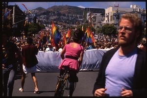 Massive crowd approaching during the San Francisco Pride Parade, carrying pride flags and banner reading 'Rightfully proud'