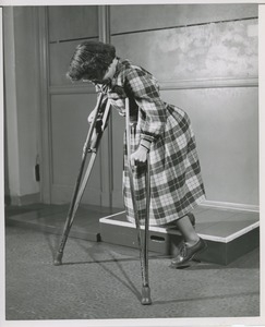 Unidentified woman with cerebral palsy walking on crutches