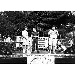 A policeman in uniform and two other men on stage at Festival Betances.