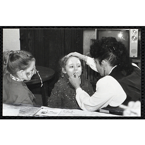 A girl getting her face painted while another looks on at a joint Charlestown Boys & Girls Club and Charlestown Against Drugs (CHAD) event