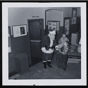 A boy accepts a gift from Santa Claus at a Christmas party