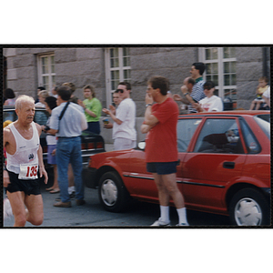 A man runs by spectators during the Bunker Hill Road Race