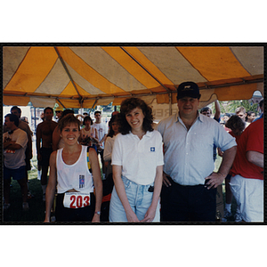 A runner poses with a woman and man during the Bunker Hill Road Race