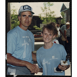 Runner Krystin Powers accepts a trophy for a man during the Battle of Bunker Hill Road Race