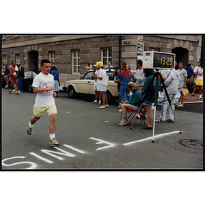 A runner crosses the finish line during the Battle of Bunker Hill Road Race