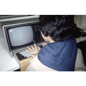 Teenager practices typing on a computer