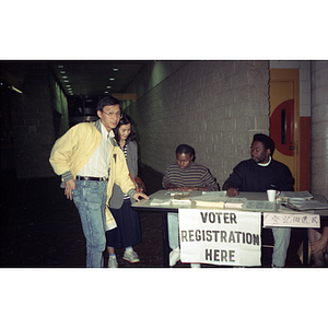 Four people at a voter registration table