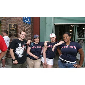 Four people pose together outside Fenway Park