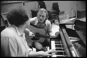 Stephen Stills with his guitar talking with Michael Sahl on piano at Wally Heider Studio 3 during production of the first Crosby, Stills, and Nash album