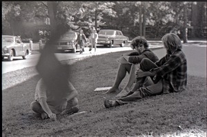 Young men seated on the grass next to copies of Free Spirit Press magazine