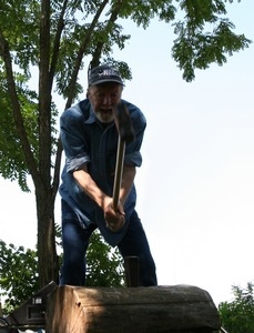 Pete Seeger taking a sledgehammer to split a log