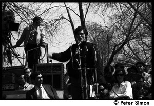 Resistance on the Boston Common: Terry Cannon (draft resister and member of the Oakland 7) addressing the crowd, Howard Zinn seated on stage (far left)