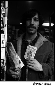 Elliot Blinder with a booklet on women's hairstyles at a Cambridge newsstand