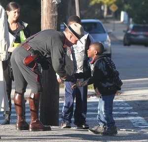 Police Col. Steven O'Donnell shakes hands with young boy, Fabrice Irakoze