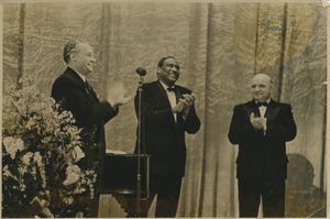 Paul Robeson clapping with two unidentified men