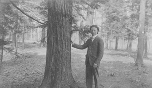 William J. Fahey, Jr. standing outdoors, by tree