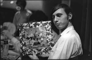 At the Boston University News Office: man holding copy of Rolling Stones', 'Their Satanic Majesties Request'
