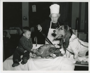 Young client with older woman and dog carving a turkey